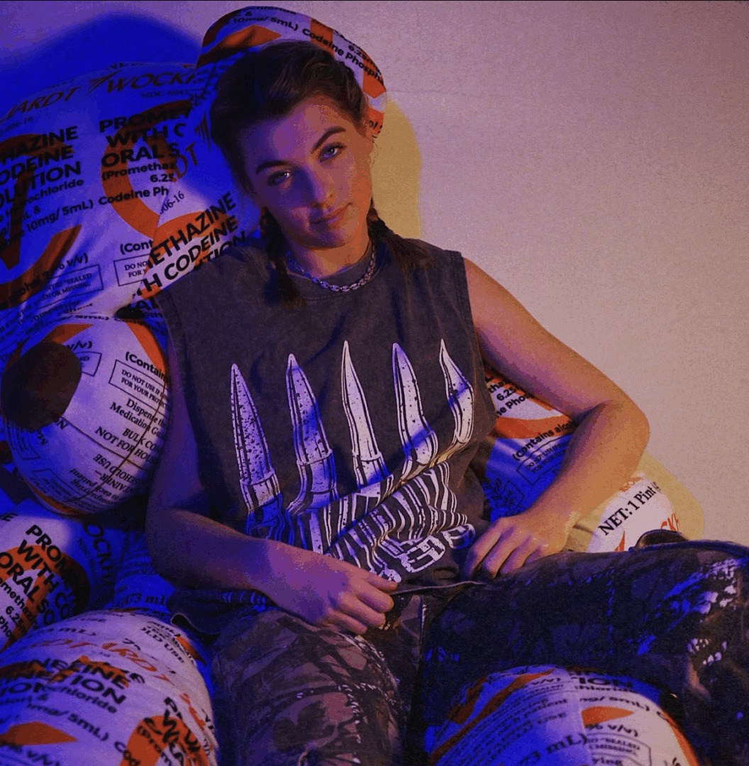 AK RENNY sitting on a huge teady bear looking thing